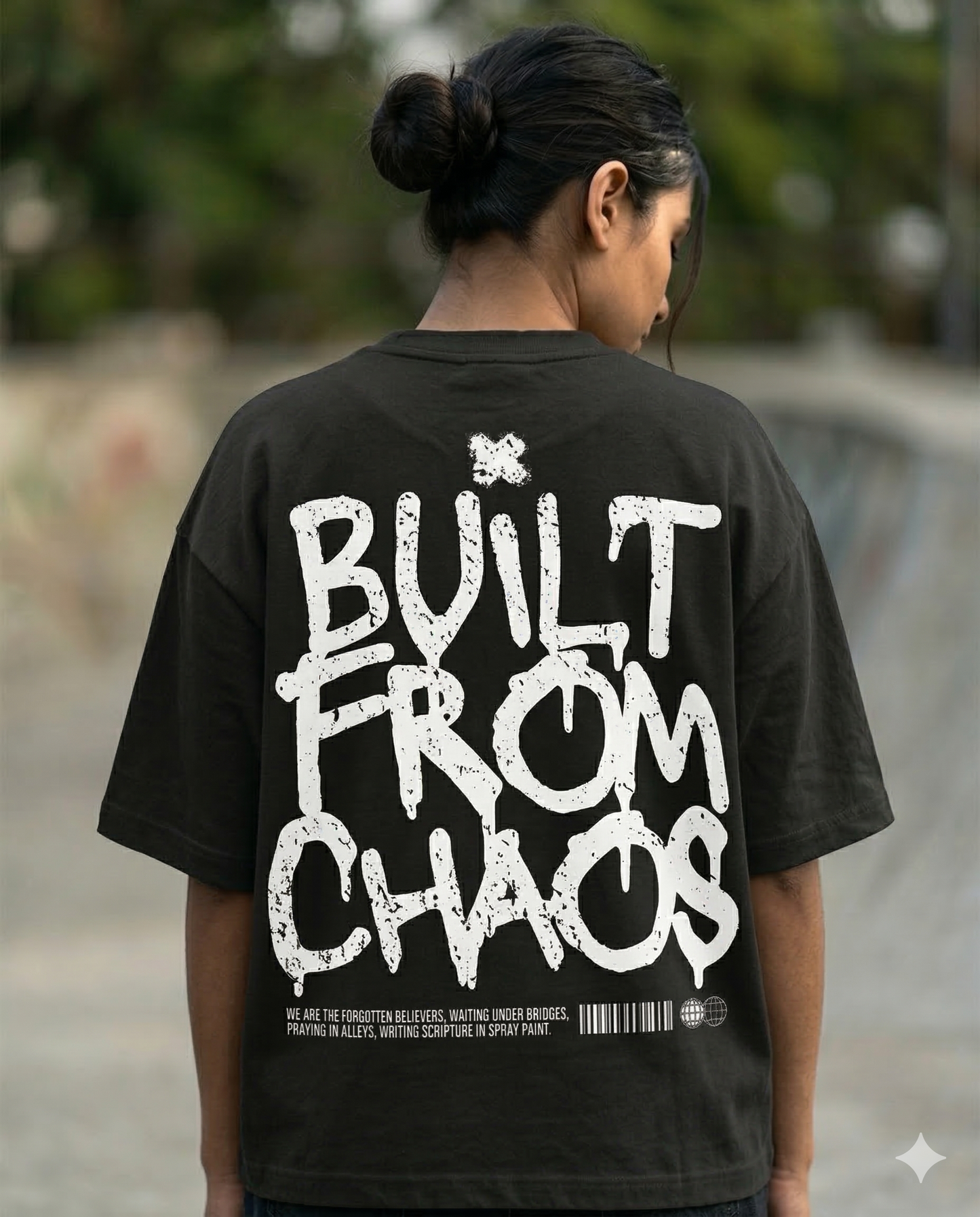 Person wearing a black t-shirt with 'Built from Chaos' text on the back.