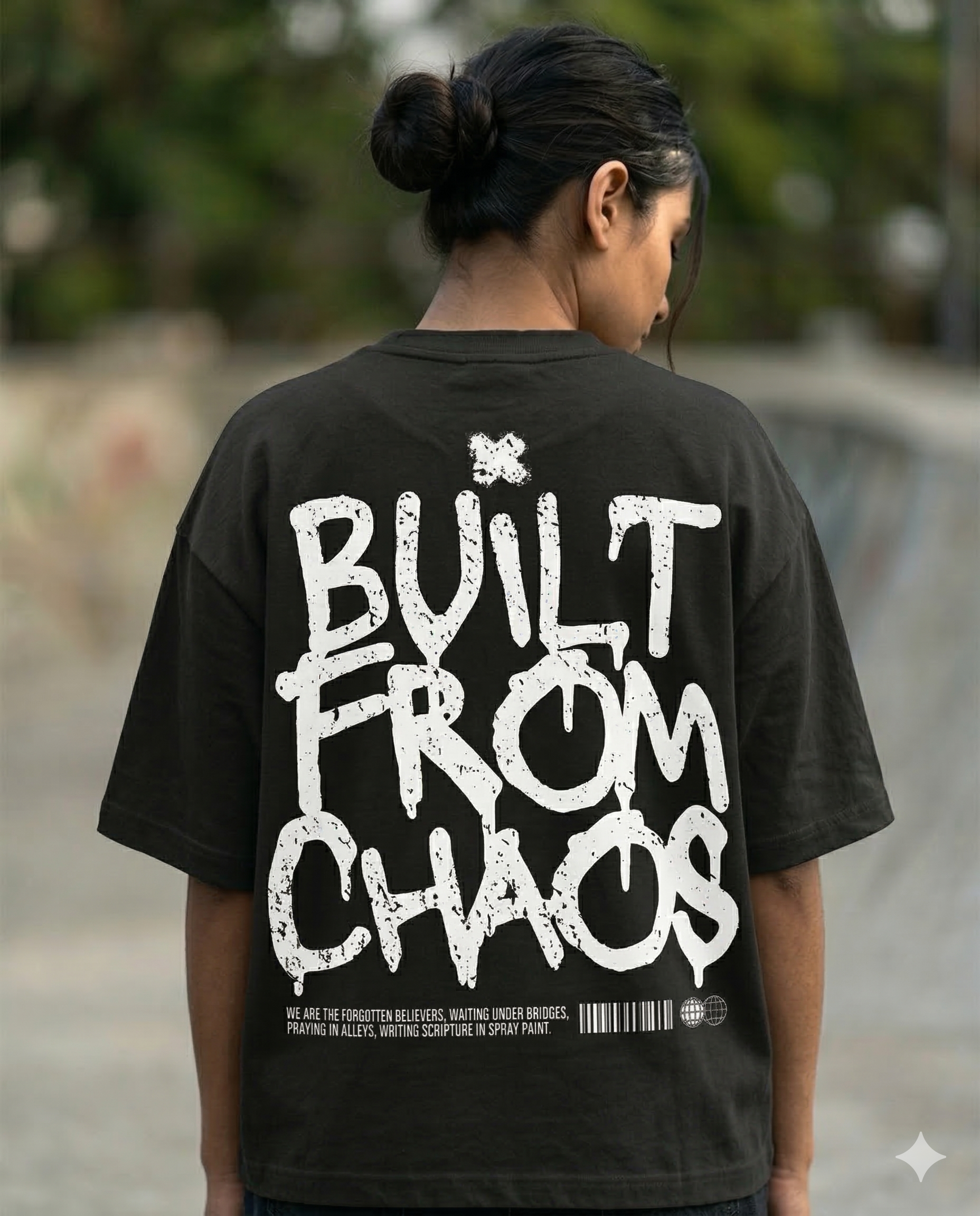 Person wearing a black t-shirt with 'Built from Chaos' text on the back.