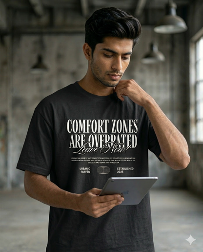 Man wearing a black t-shirt with motivational quote, holding a tablet in an industrial setting.