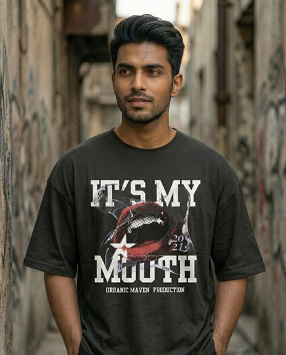 Man wearing a black t-shirt with graphic design and text in an alleyway.